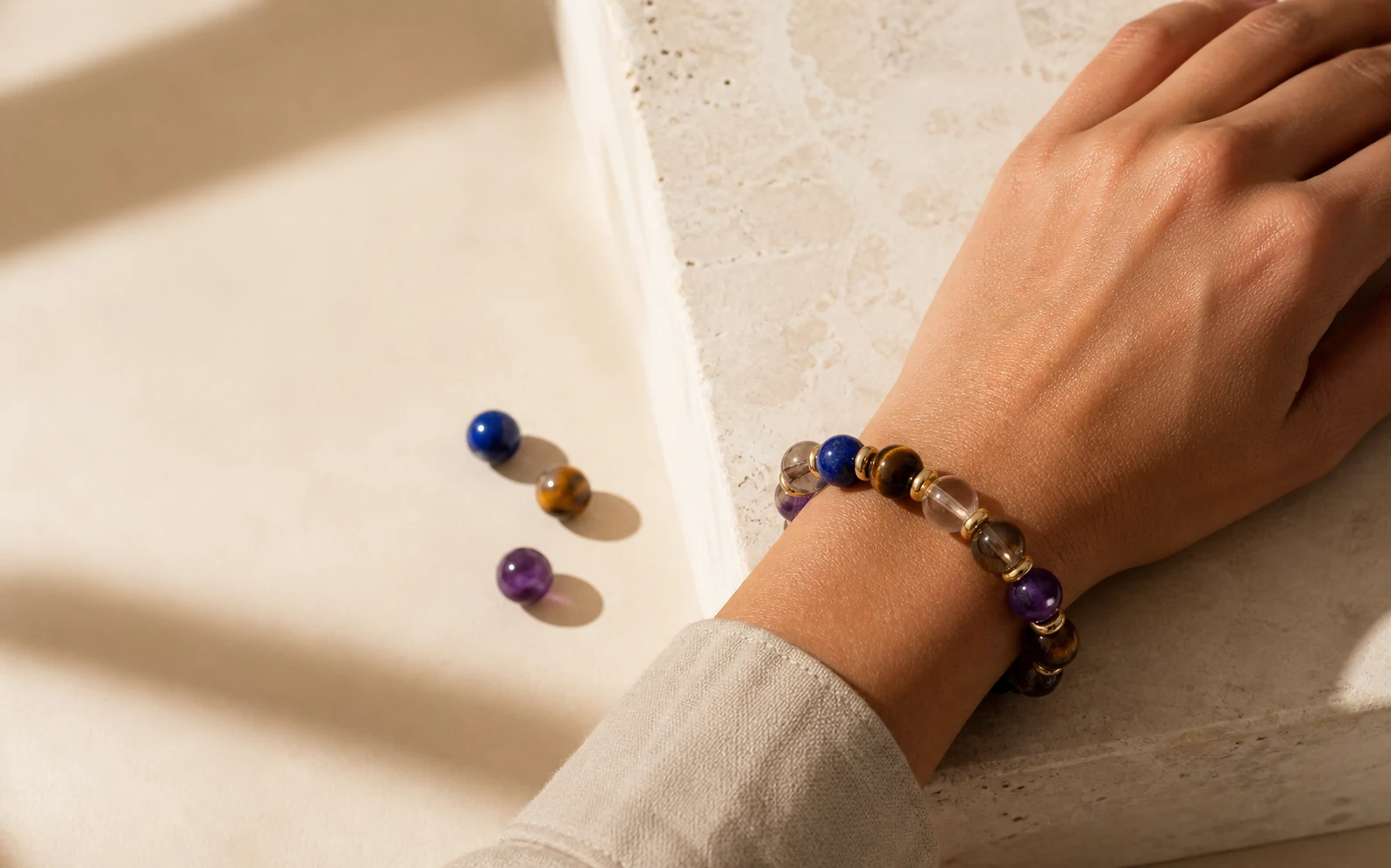 Mixed natural-stone bracelet worn on a wrist in warm window light
